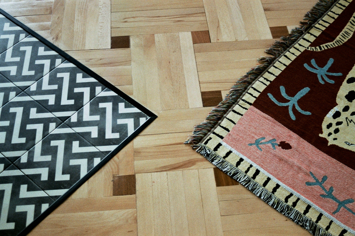 a close up of two rugs on a wooden floor